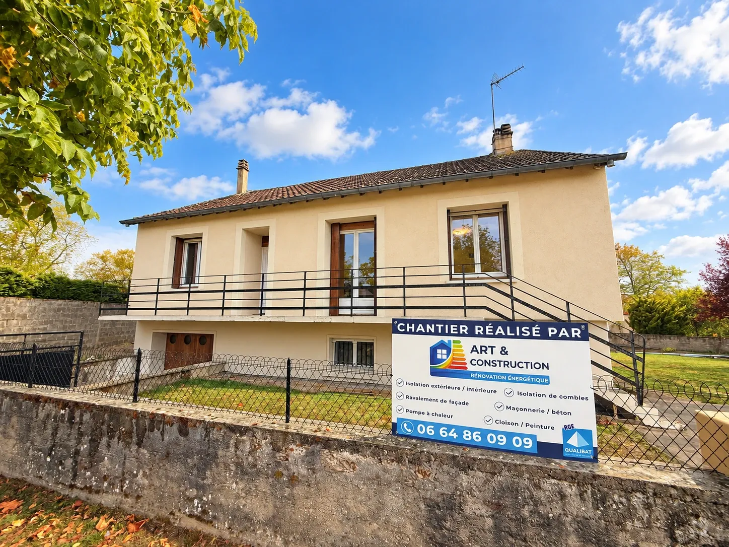 Maison sur sous-sol à Saint-Pierre-le-Moûtier après isolation par l’extérieur, vue depuis la rue avec le panneau de chantier Art et Construction