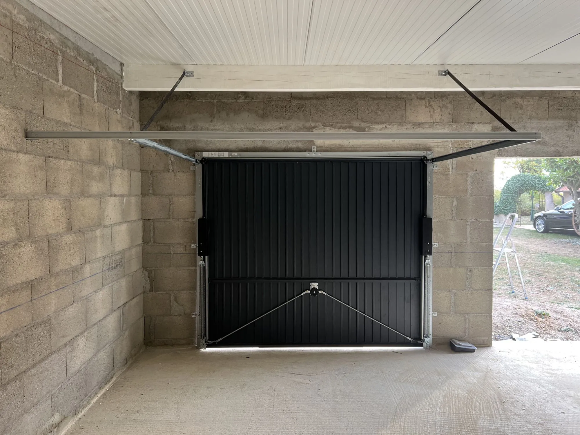 Intérieur du garage : porte basculante posée, sous-face du bac acier isolé