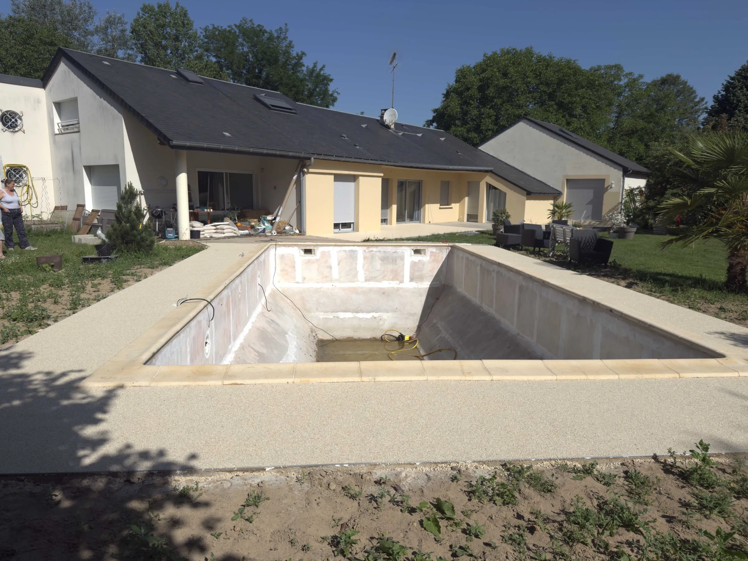 Après : Les abords de la piscine pendant le terrassement, puis recouverts de résine drainante