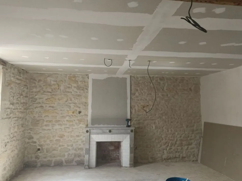 Pièce avec mur en pierre rejointoyé et plafond en plaques de plâtre