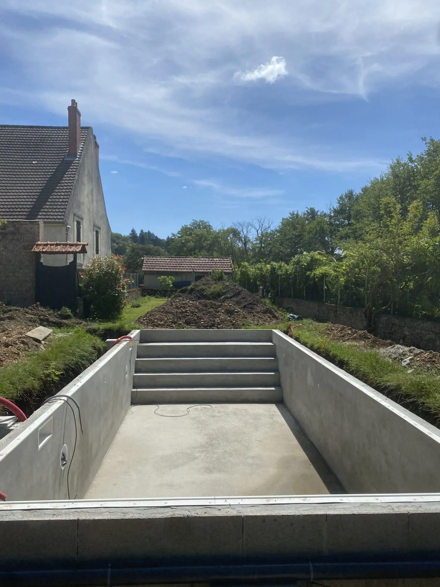 Bassin enduit avec escalier intégré, prêt à recevoir le liner