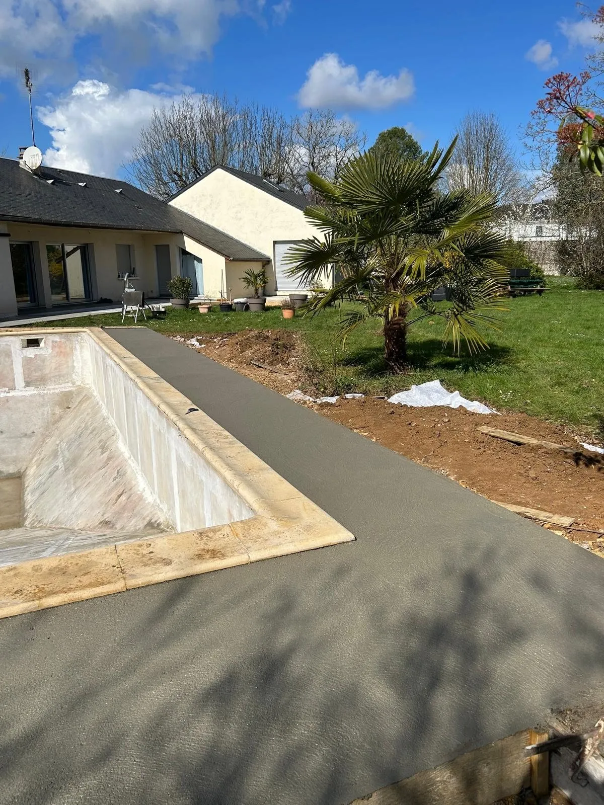 Dalle béton fraîchement coulée le long d’une piscine
