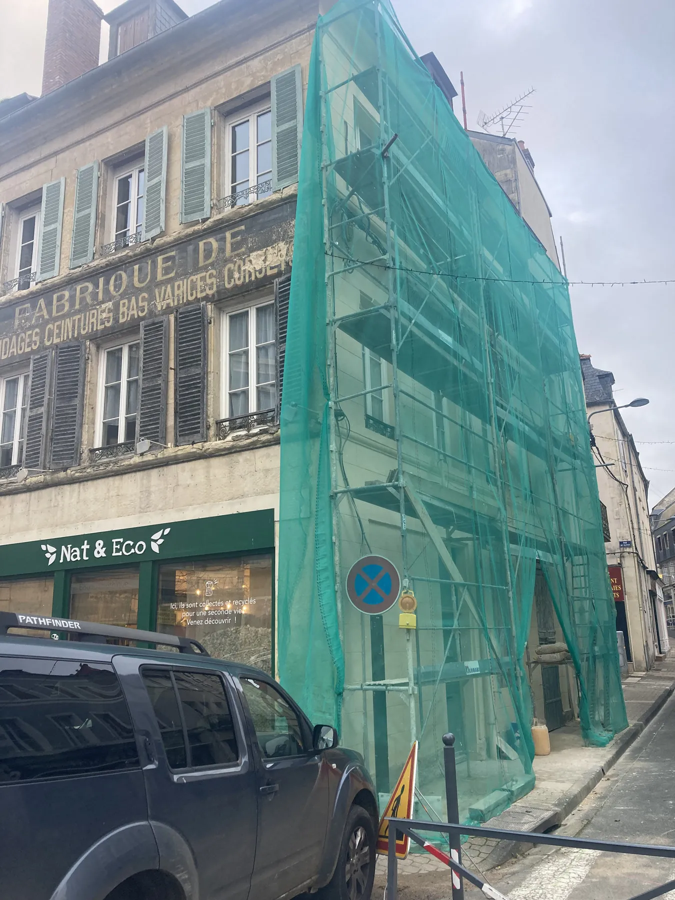 Échafaudage avec filet de protection sur la façade d’un immeuble ancien, côté rue