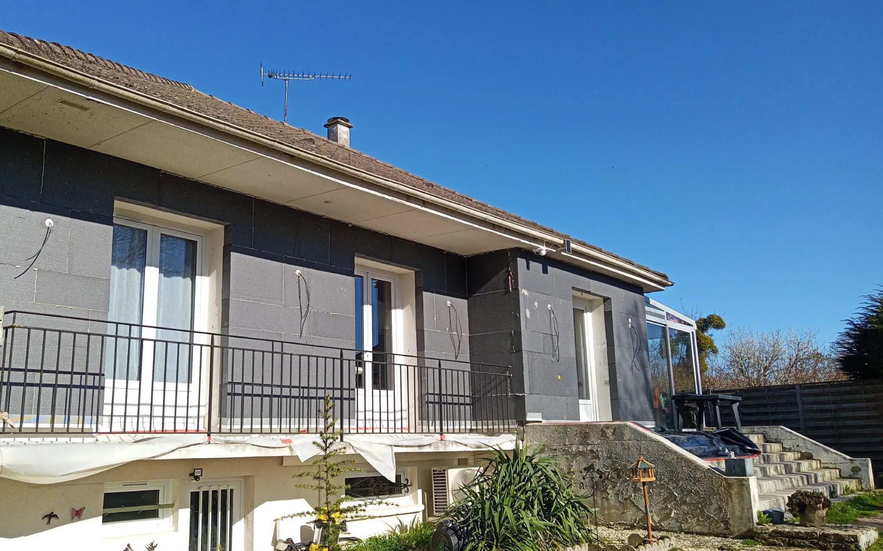Pose des panneaux isolants gris sur la façade