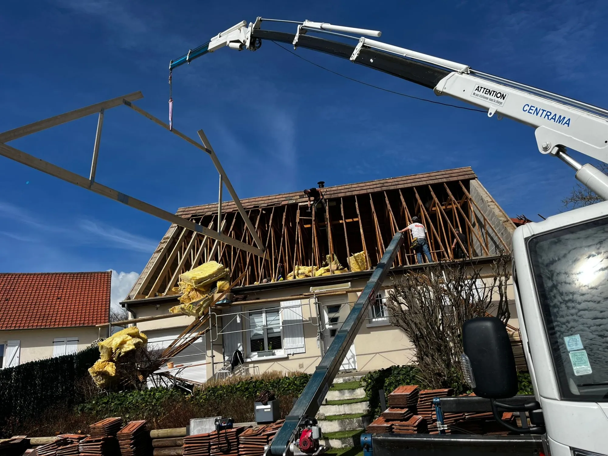 Levage à la grue d’une fermette aménageable au-dessus de la maison de Moulins, toiture ouverte