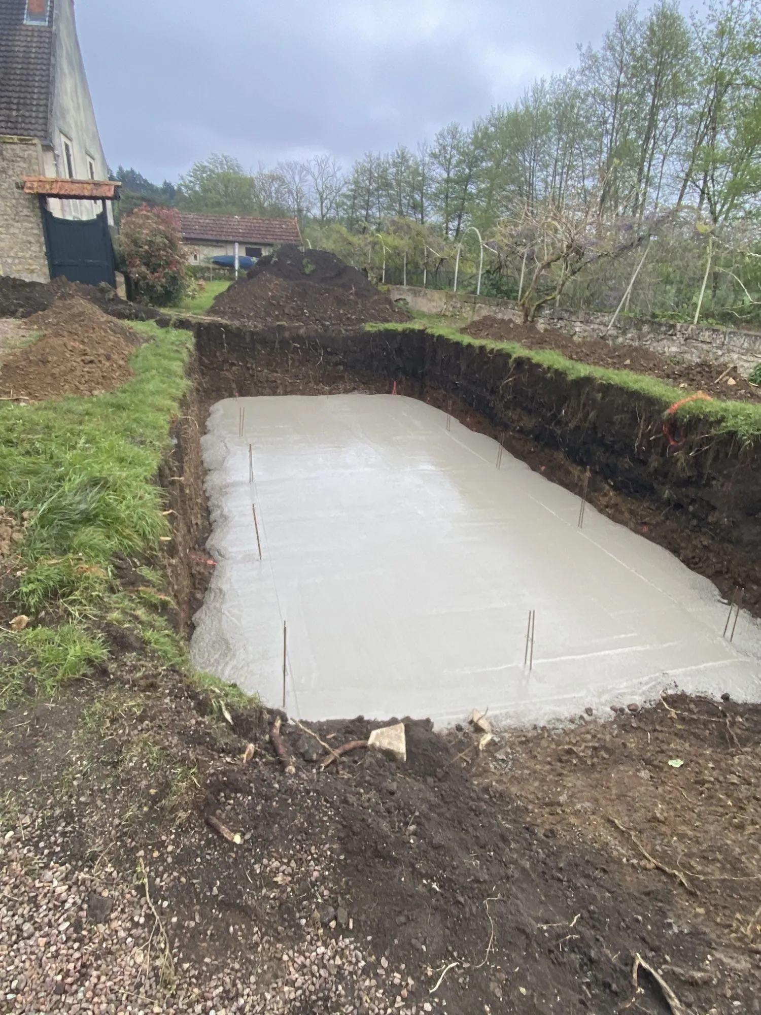 Radier en béton armé coulé pour une piscine, aciers en attente