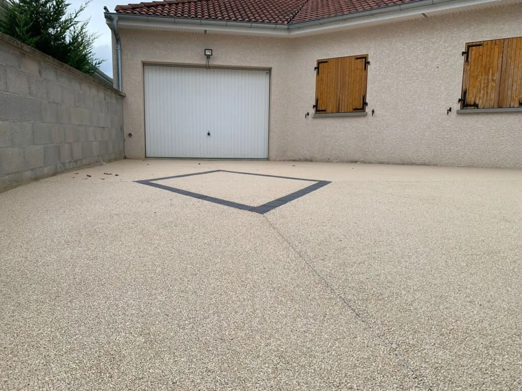 Cour en revêtement de granulats liés, devant un garage